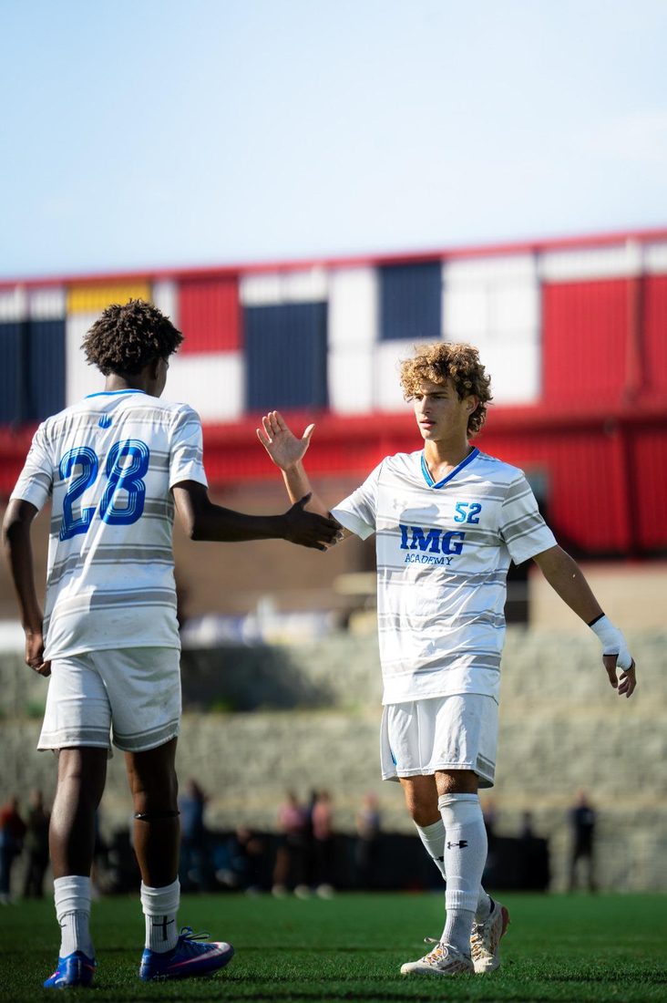 Two team-mates high-fiving on the pitch